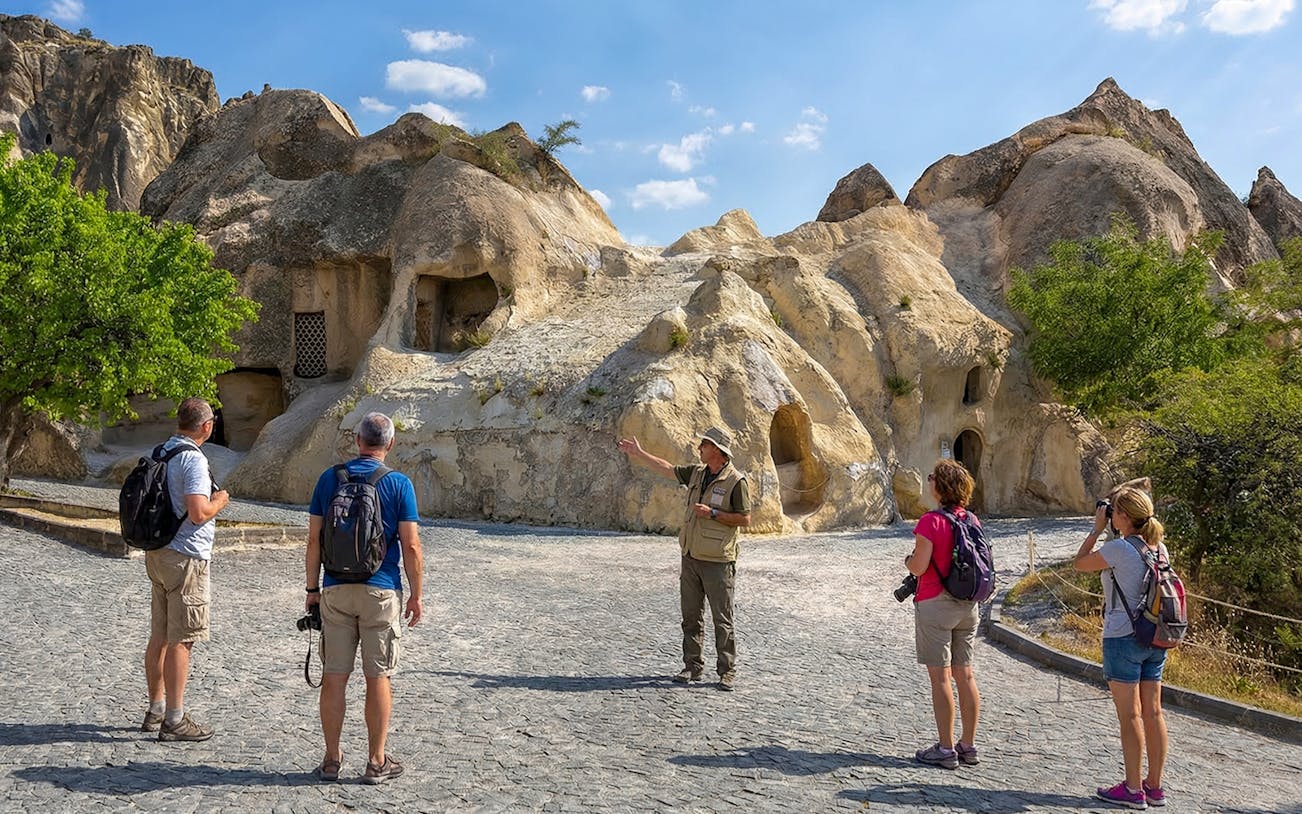 Tour guide explaining rock formations at Goreme Open-Air Museum, Cappadocia.