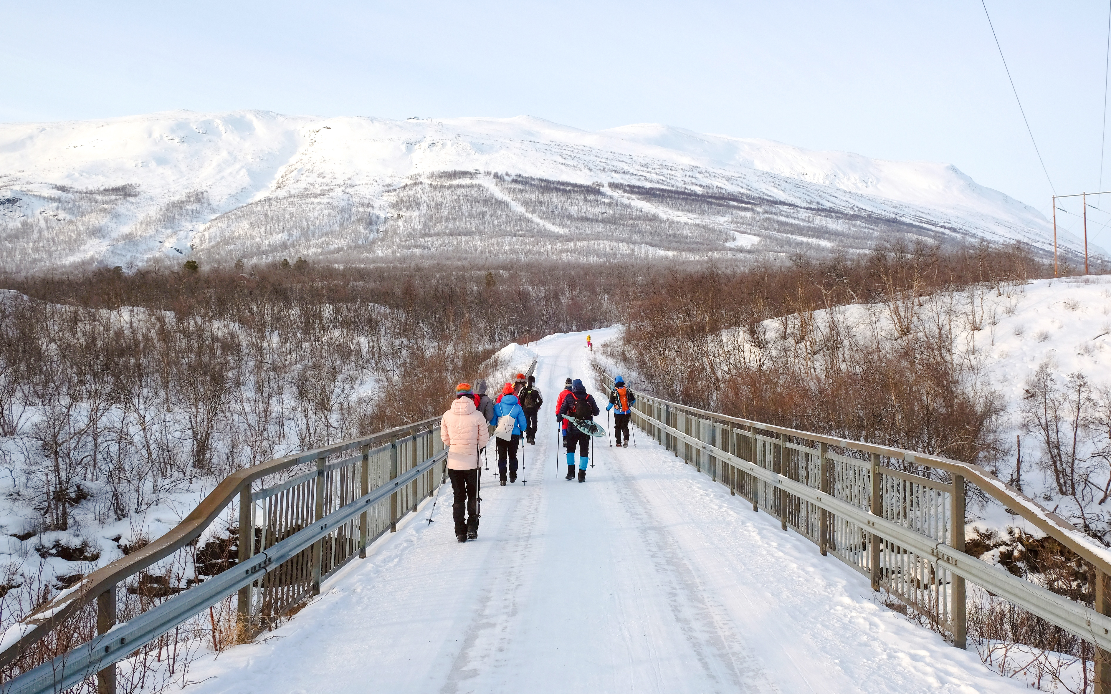 Tourists hiking on snowy trail in Abisko National Park, Lapland.