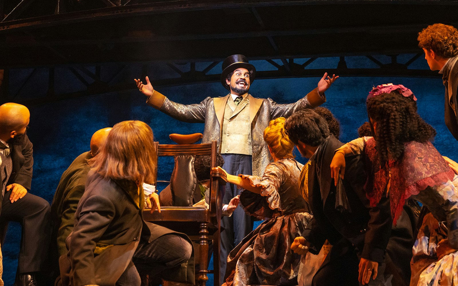 Performer in top hat engaging audience during Sweeney Todd musical scene.
