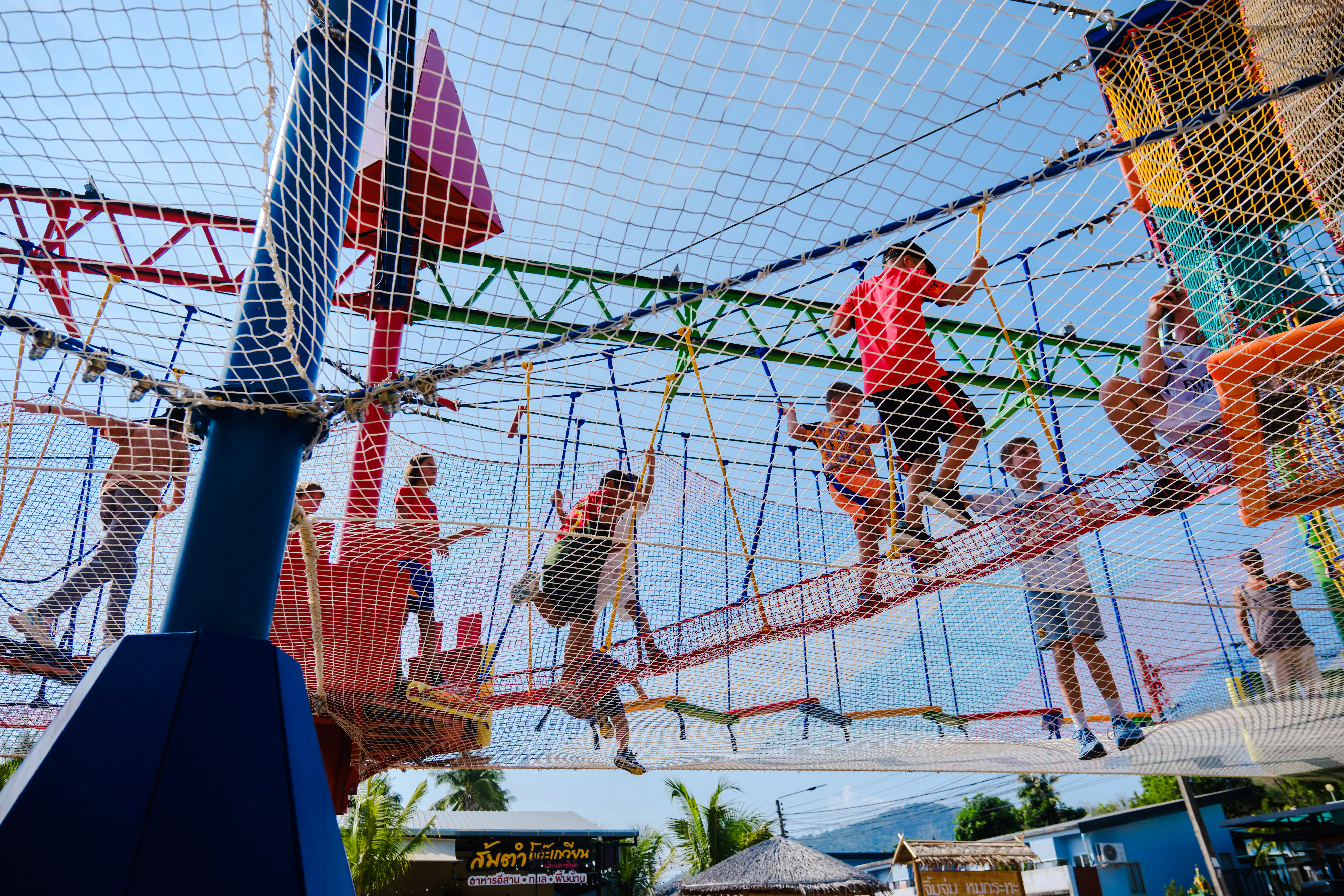 Children playing on a netted adventure course during a birthday party in Phuket.