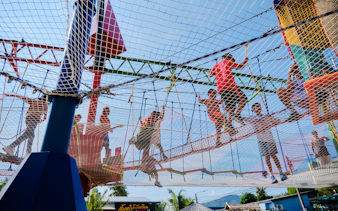 Children playing on a netted adventure course during a birthday party in Phuket.