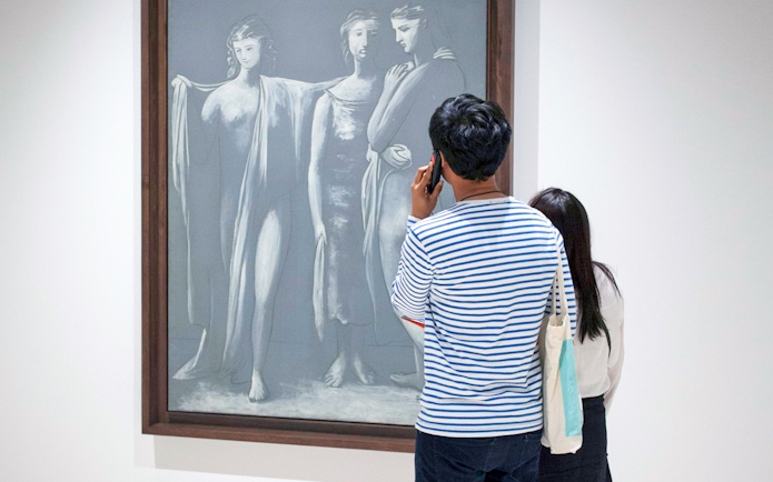 Visitor using audio guide in front of Picasso artwork at Picasso Museum Malaga.