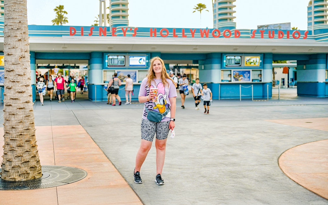 Woman standing in front of Disney Hollywood Studios entrance, Walt Disney World Resort, Orlando.