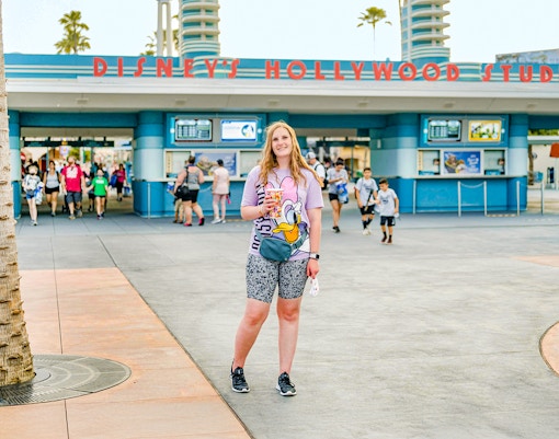 Woman standing in front of Disney Hollywood Studios entrance, Walt Disney World Resort, Orlando.