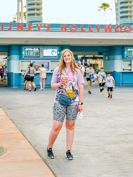Woman standing in front of Disney Hollywood Studios entrance, Walt Disney World Resort, Orlando.