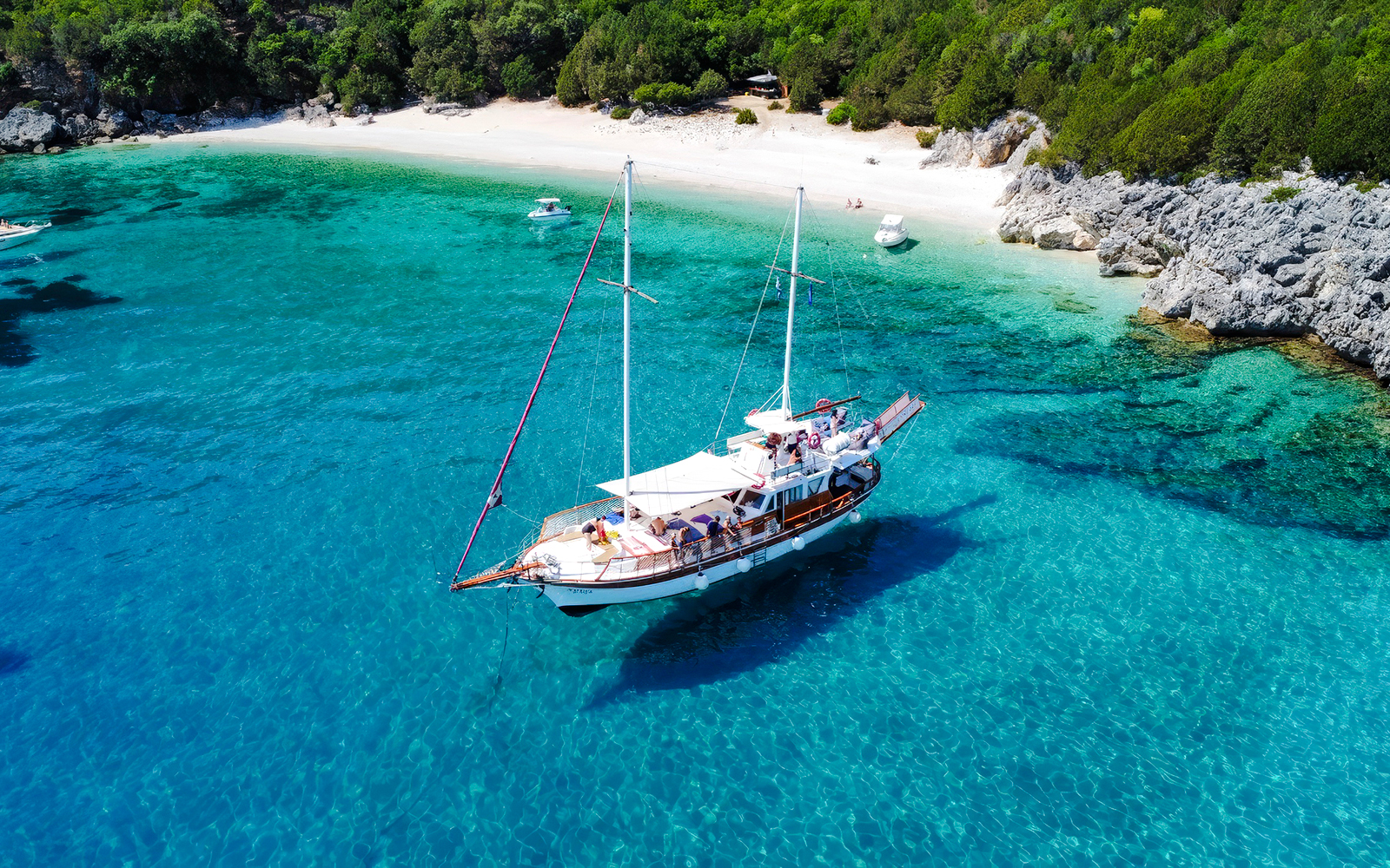 Sailing boat near a secluded beach on a Rhodes all-inclusive cruise.