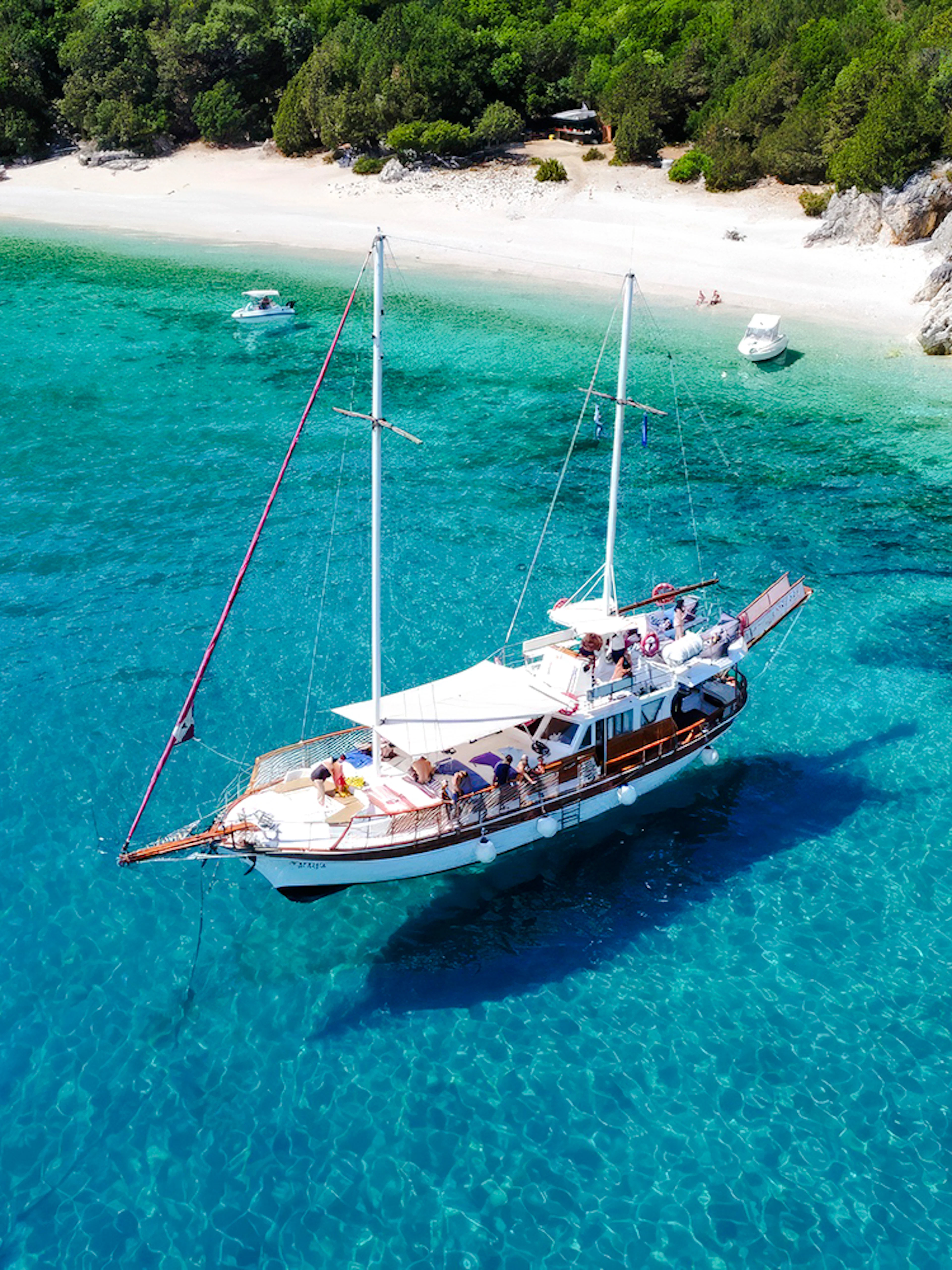 Sailing boat near a secluded beach on a Rhodes all-inclusive cruise.