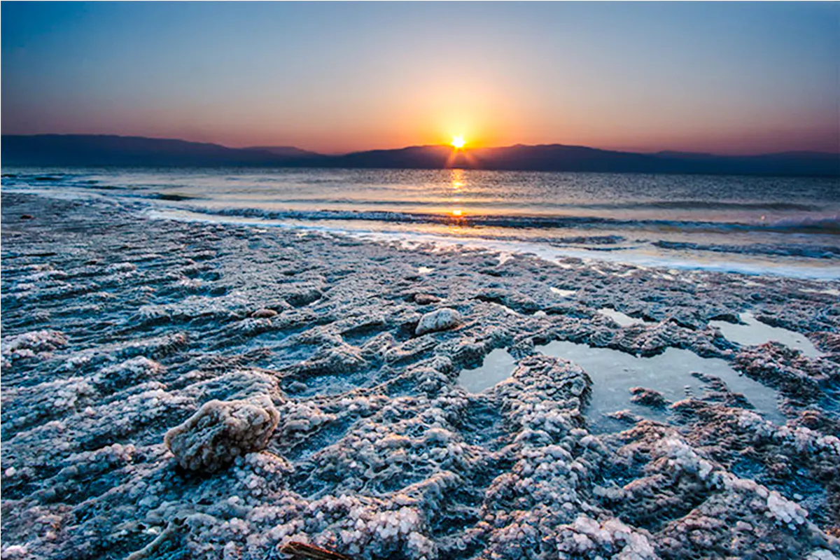 Sunrise over the Dead Sea with salt formations on the shore, Amman half-day trip.