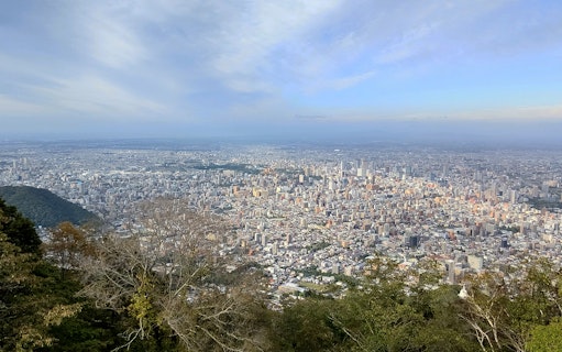 Aerial view of Sapporo cityscape from Mt. Moiwa, showcasing urban landscape and surrounding greenery.