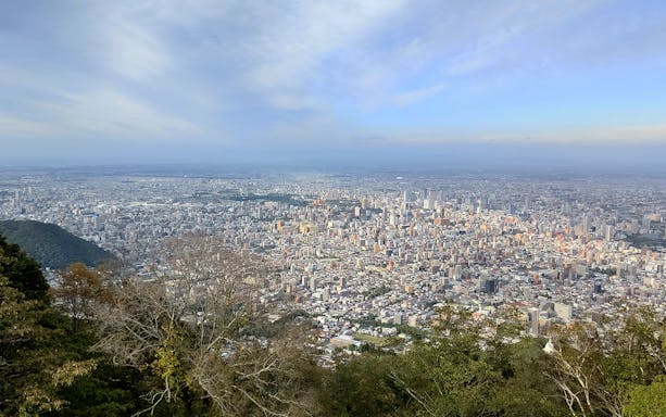 Aerial view of Sapporo cityscape from Mt. Moiwa, showcasing urban landscape and surrounding greenery.