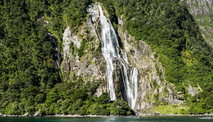 Stirling Falls cascading into Milford Sound fjord, New Zealand.