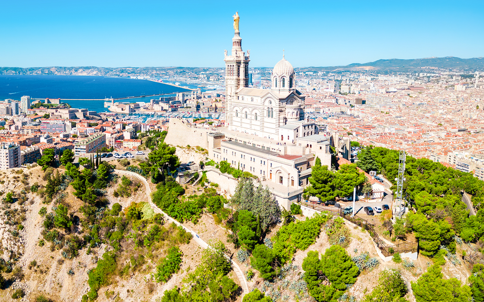 Notre-Dame de la Garde overlooking Marseille with cityscape and coastline in view.
