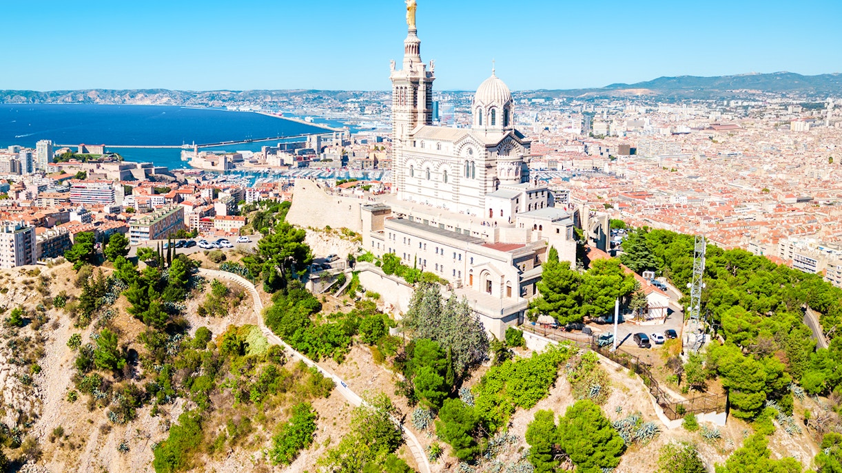 Notre-Dame de la Garde overlooking Marseille with cityscape and coastline in view.