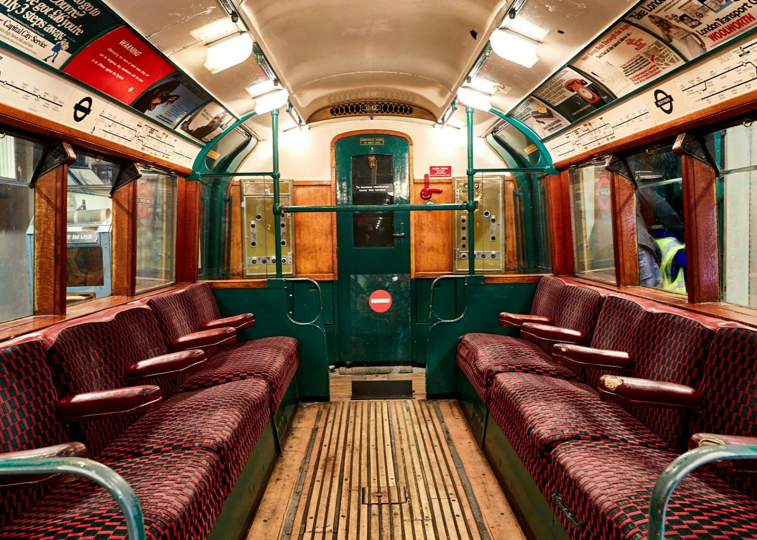 Interior of a vintage London Underground train carriage from the wartime era.