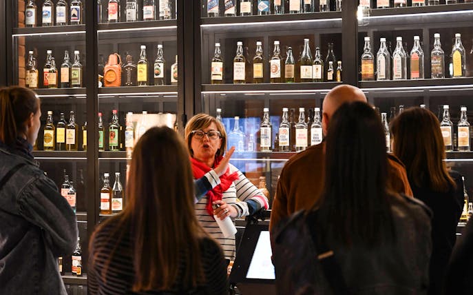 Tour group at vodka museum in Krakow, guide explaining vodka history.