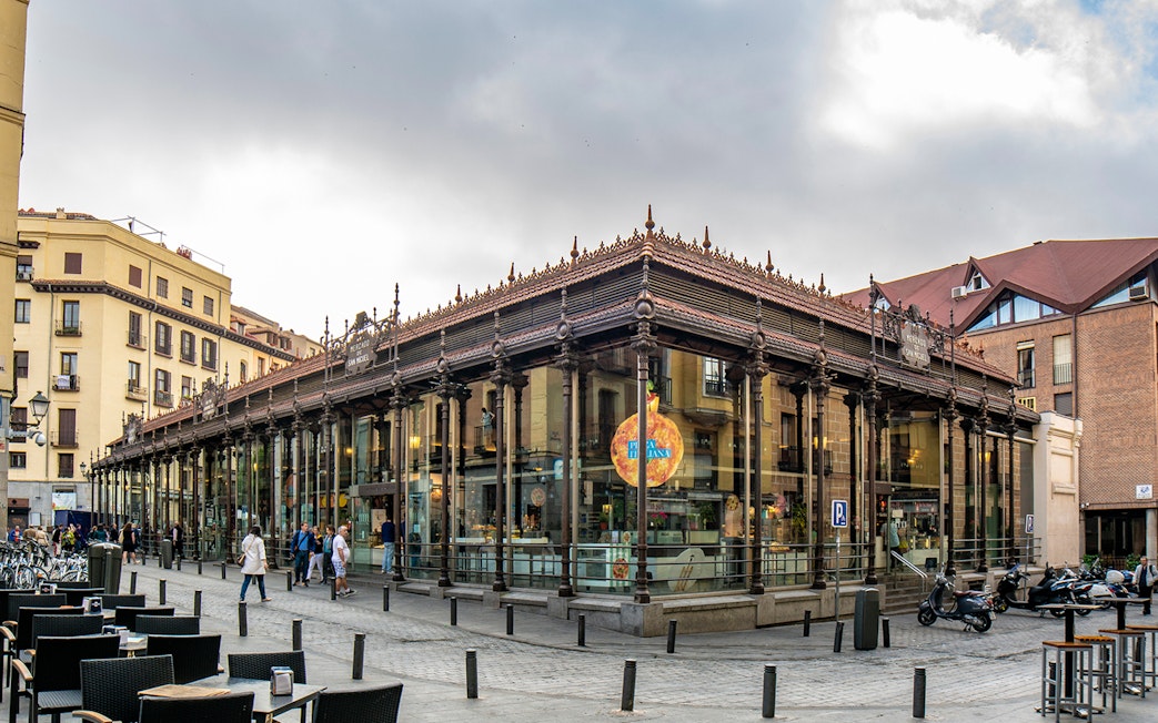 San Miguel Market in Madrid with people walking outside.
