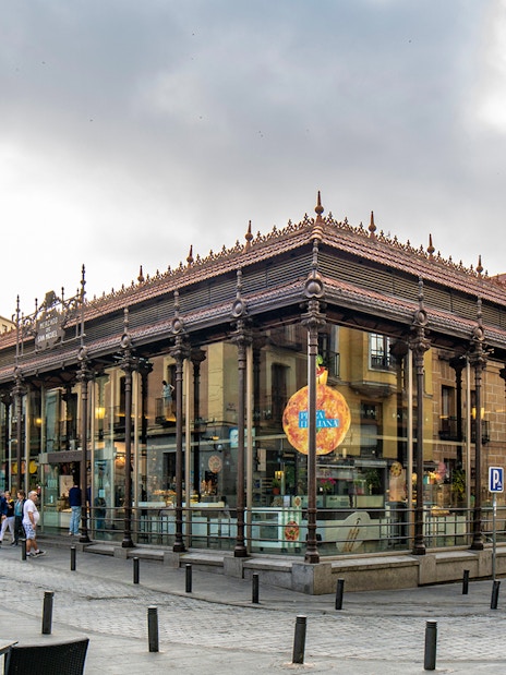 San Miguel Market in Madrid with people walking outside.