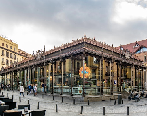 San Miguel Market in Madrid with people walking outside.