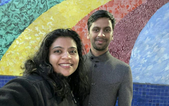 Couple in front of colorful mural in Haight Ashbury, San Francisco.