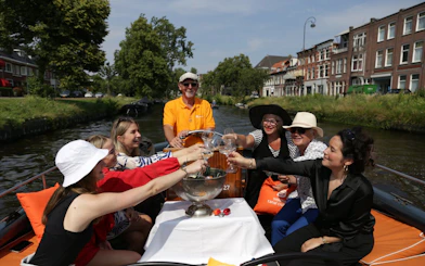 Group enjoying a toast on a Haarlem canal cruise with live skipper commentary.