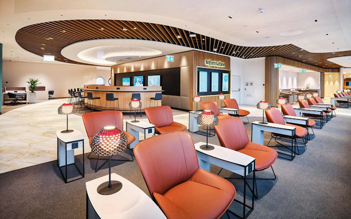 Vienna Airport Terminal 1 lounge seating area with information desk.