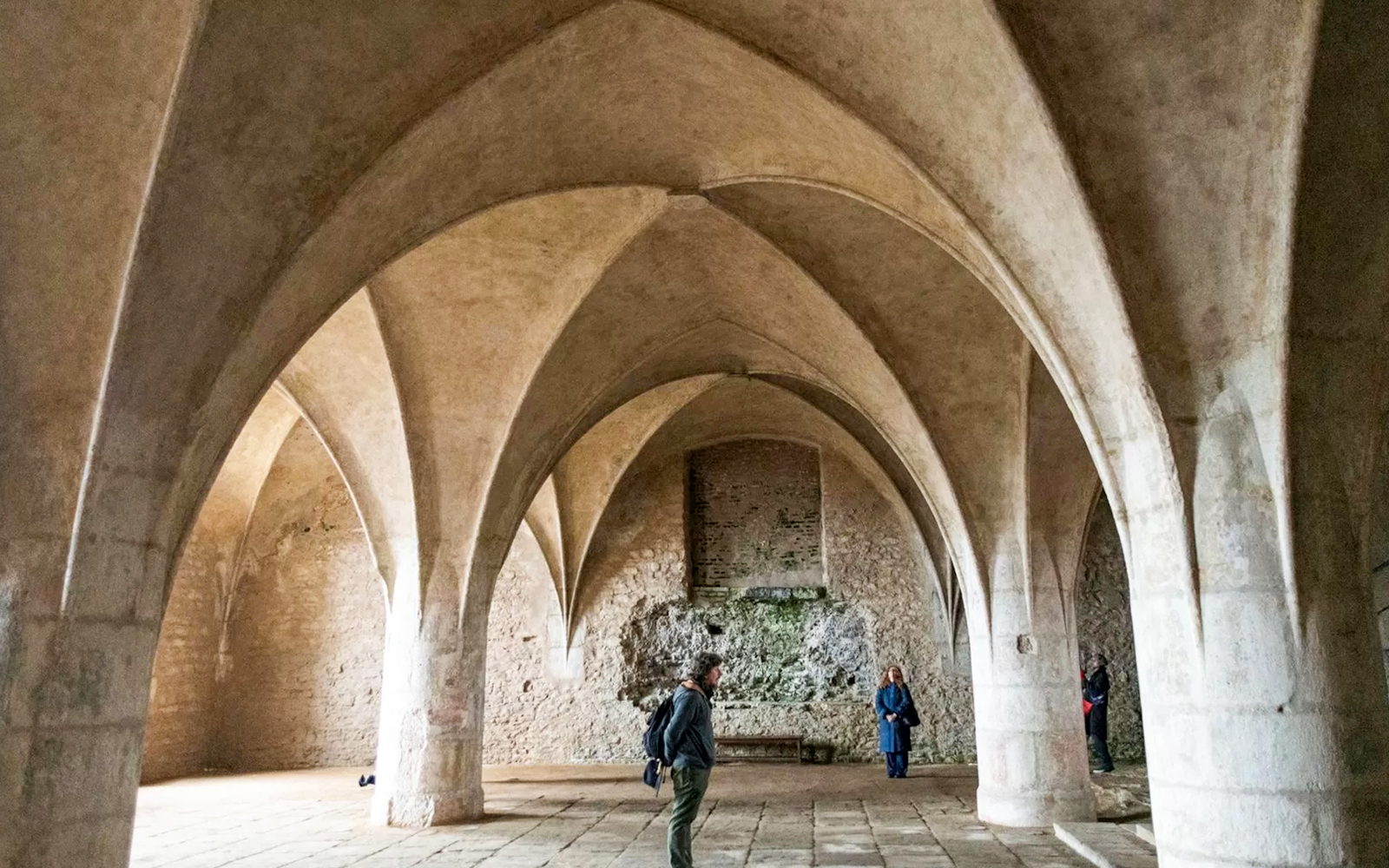 Visitors inside the Bone Church in Kutna Hora, admiring vaulted ceilings and stone walls.