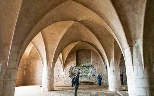 Visitors inside the Bone Church in Kutna Hora, admiring vaulted ceilings and stone walls.