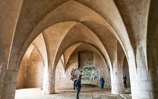 Visitors inside the Bone Church in Kutna Hora, admiring vaulted ceilings and stone walls.