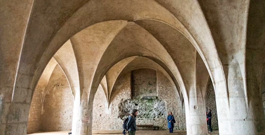 Visitors inside the Bone Church in Kutna Hora, admiring vaulted ceilings and stone walls.