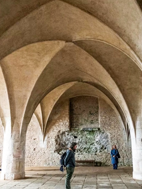 Visitors inside the Bone Church in Kutna Hora, admiring vaulted ceilings and stone walls.