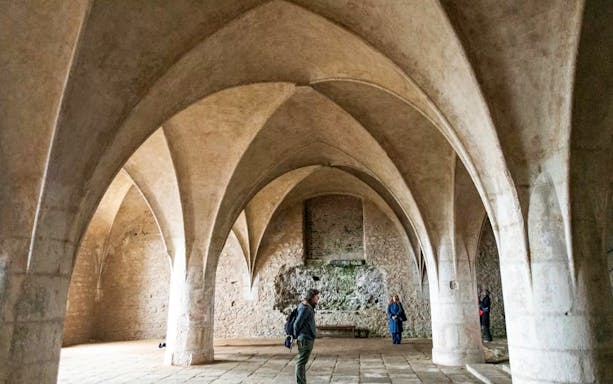 Visitors inside the Bone Church in Kutna Hora, admiring vaulted ceilings and stone walls.