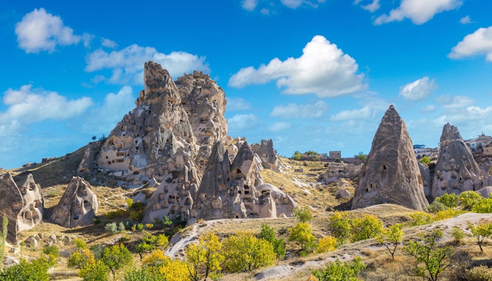 Goreme Open Air Museum rock formations under a blue sky in Cappadocia, Turkey.