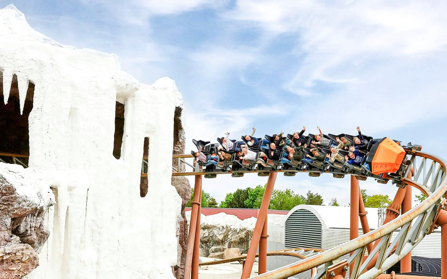Roller coaster riders on Polar X-plorer at LEGOLAND® Billund near icy cave.