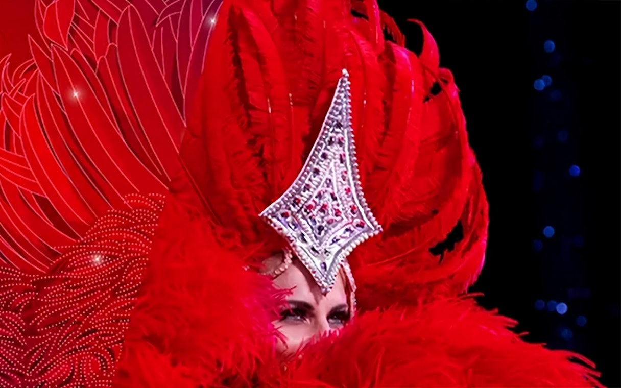 Performer in red feathered costume at Moulin Rouge Valentine's Day event.