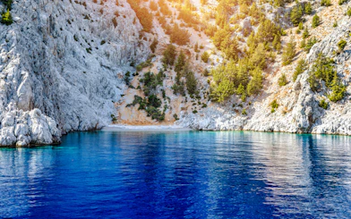 Rocky cliffs and clear blue water at St George's Bay, Symi Island, Rhodes.