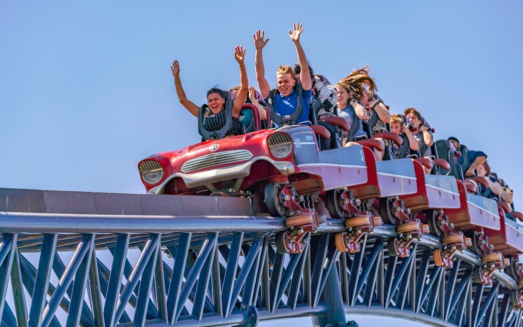 Riders with hands up on THE SWARM roller coaster at Thorpe Park Resort.