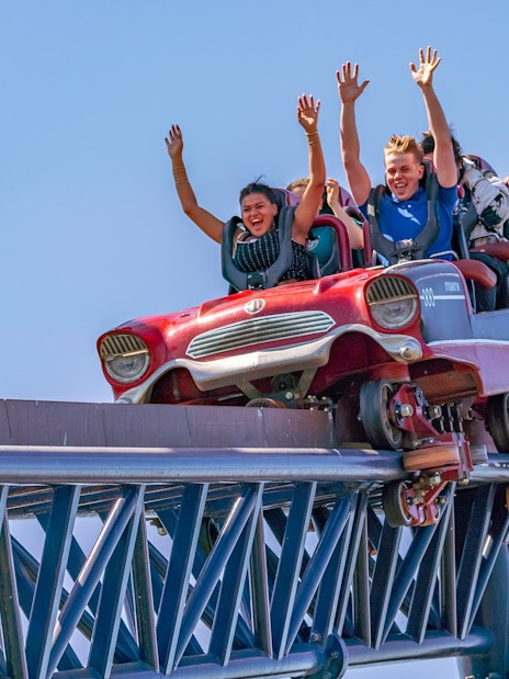 Riders with hands up on THE SWARM roller coaster at Thorpe Park Resort.