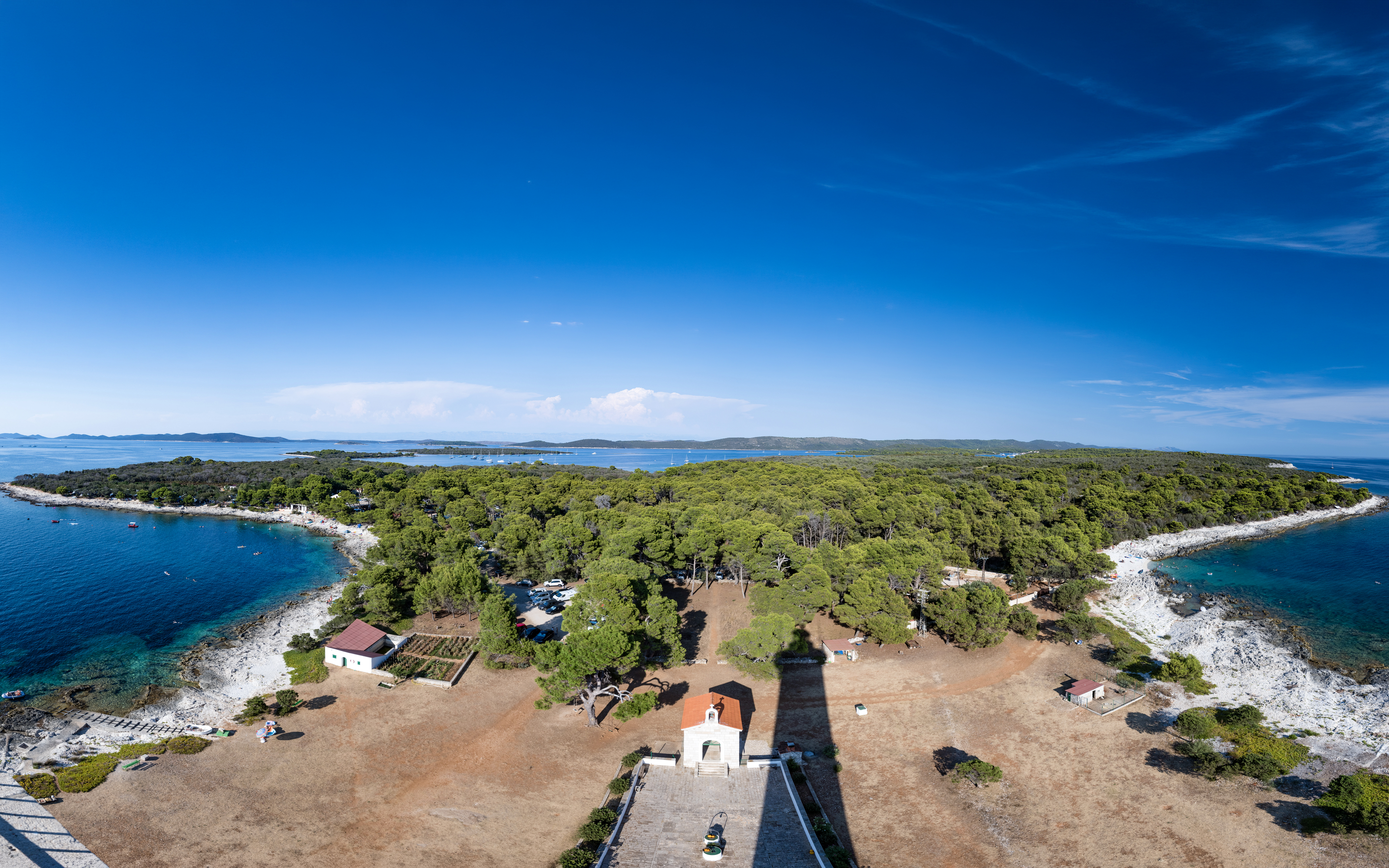 Veli Rat Lighthouse viewpoint overlooking Adriatic Sea and forested coastline, Croatia.