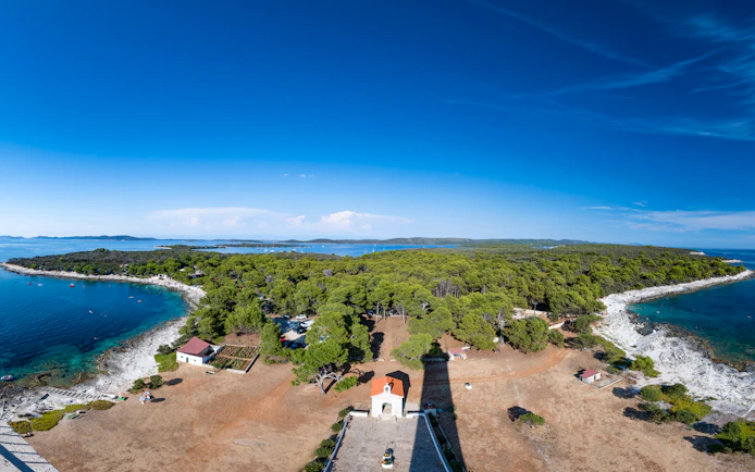 Veli Rat Lighthouse viewpoint overlooking Adriatic Sea and forested coastline, Croatia.