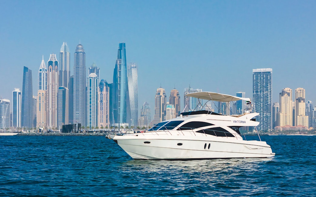 Viktoriia luxury yacht sailing with Dubai skyline in the background.