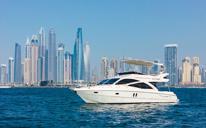 Viktoriia luxury yacht sailing with Dubai skyline in the background.