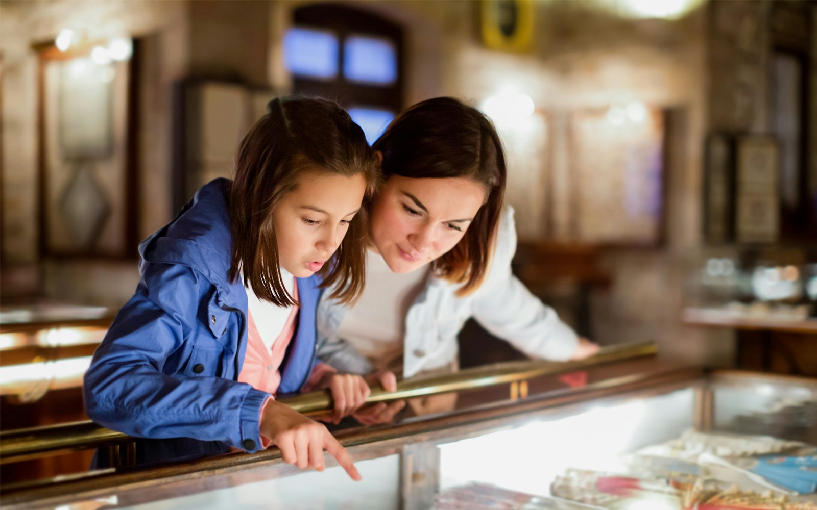 Mother and daughter exploring exhibits at Gaudí House Museum, Spain.