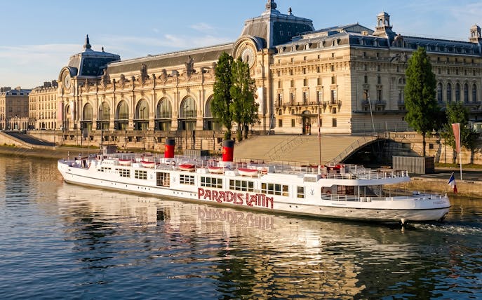 Dinner cruise boat on the Seine River in front of Musée d'Orsay, Paris.