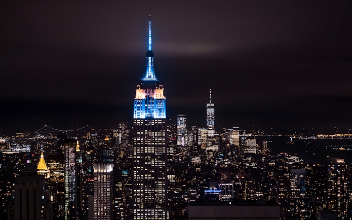 New York City skyline with illuminated skyscrapers at night from Big Bus tour.