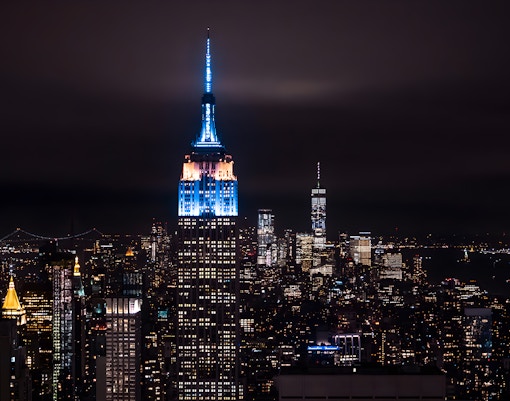 New York City skyline with illuminated skyscrapers at night from Big Bus tour.