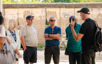 Tour group listening to a guide near the Berlin Wall during a walking tour on the Third Reich and Cold War.
