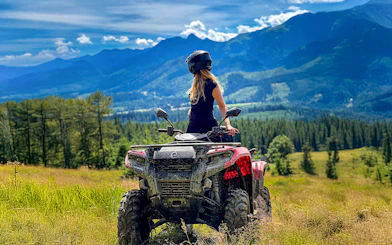 Visitor on quad bike overlooking Zakopane mountains and forest.
