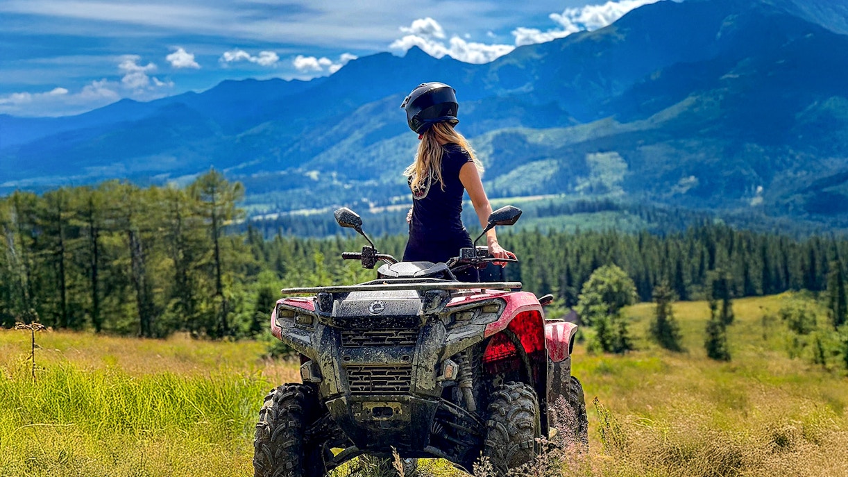 Visitor on quad bike overlooking Zakopane mountains and forest.
