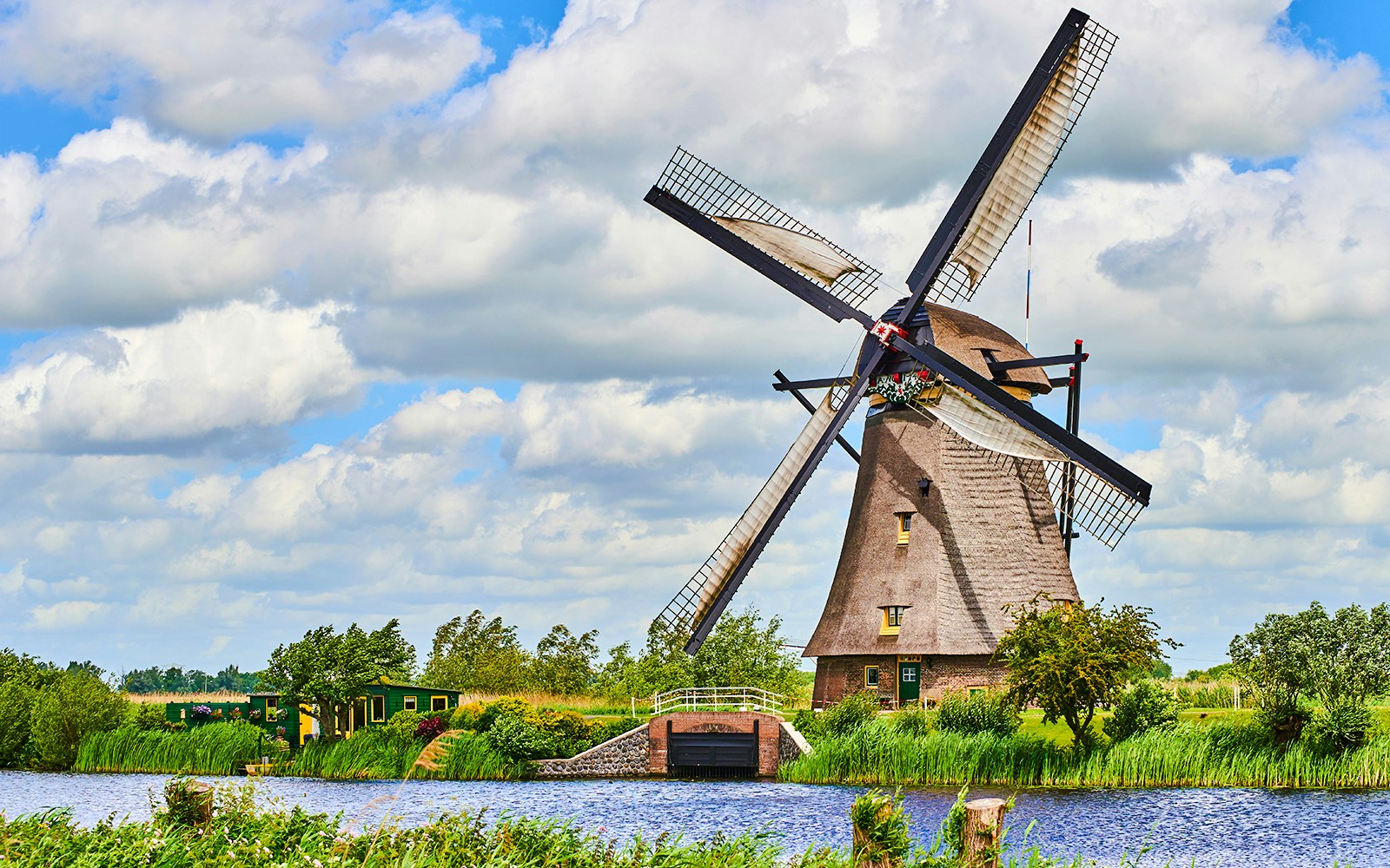 Windmill in Kinderdijk, Netherlands, surrounded by greenery and water.