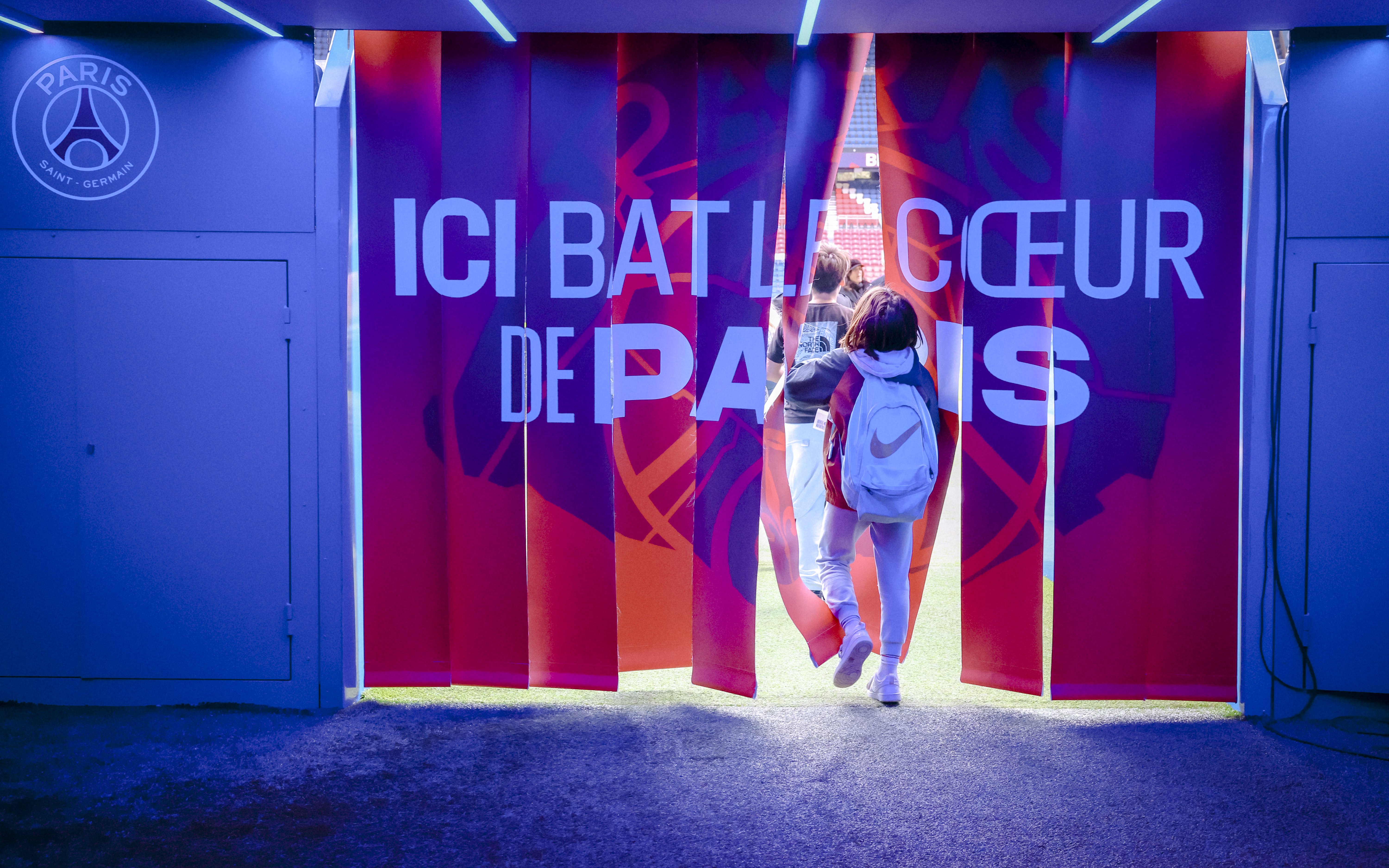 Visitors entering PSG Stadium through a tunnel in Paris, France.